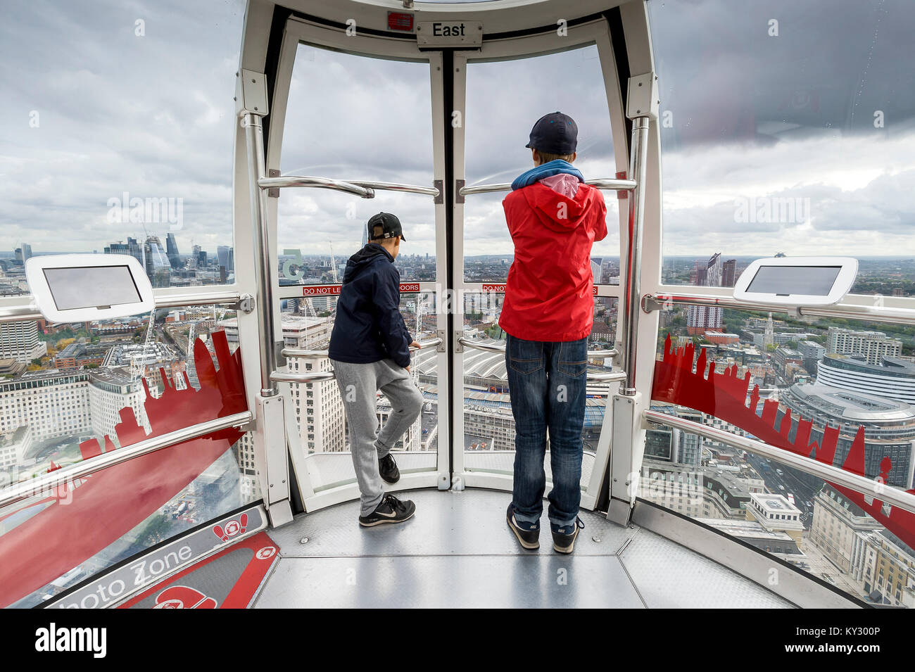 two boys look out of the window of London`s Big Eye Stock Photo